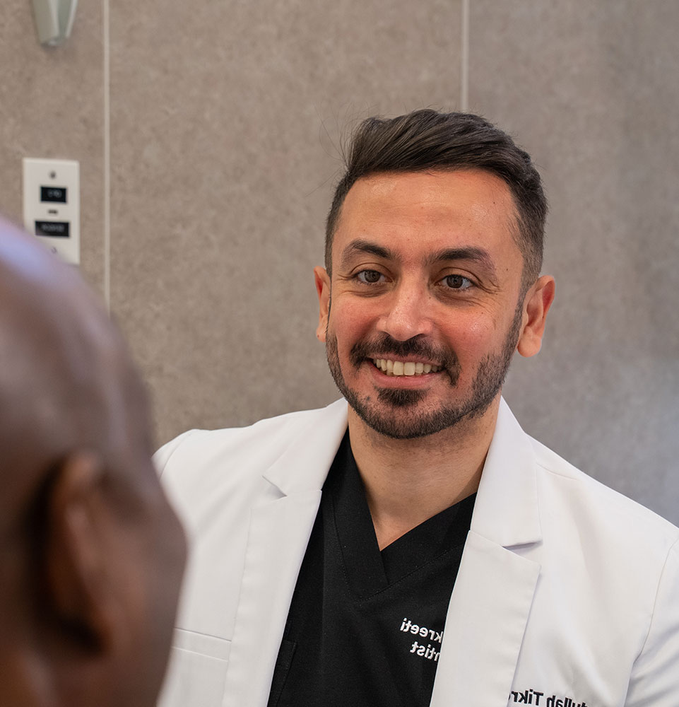 doctor smiling brightly while going over dental procedure information with patient