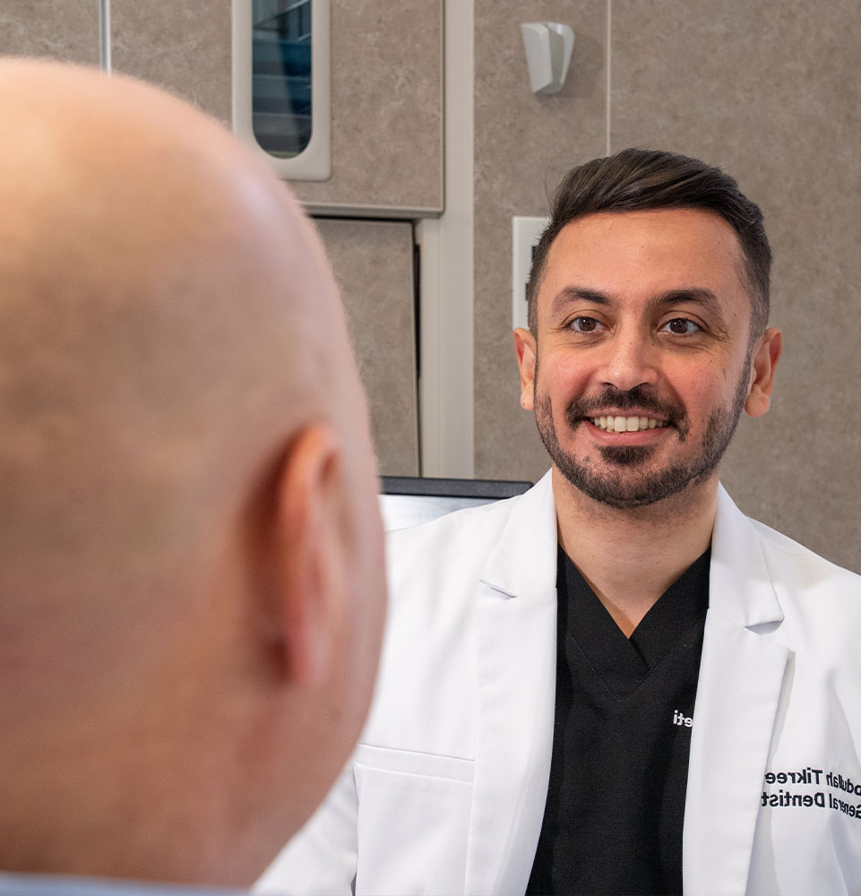 doctor smiling while going over dental information with patient