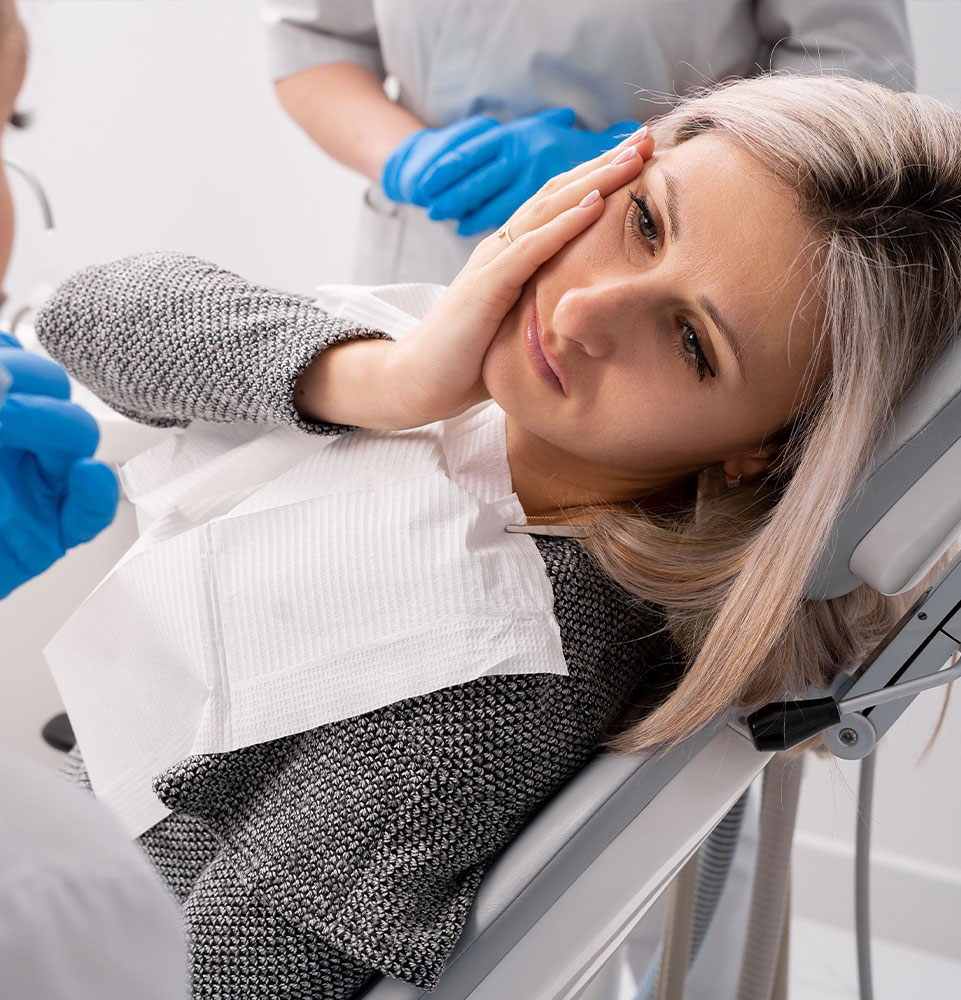 girl with toothache sits in a dental chair.