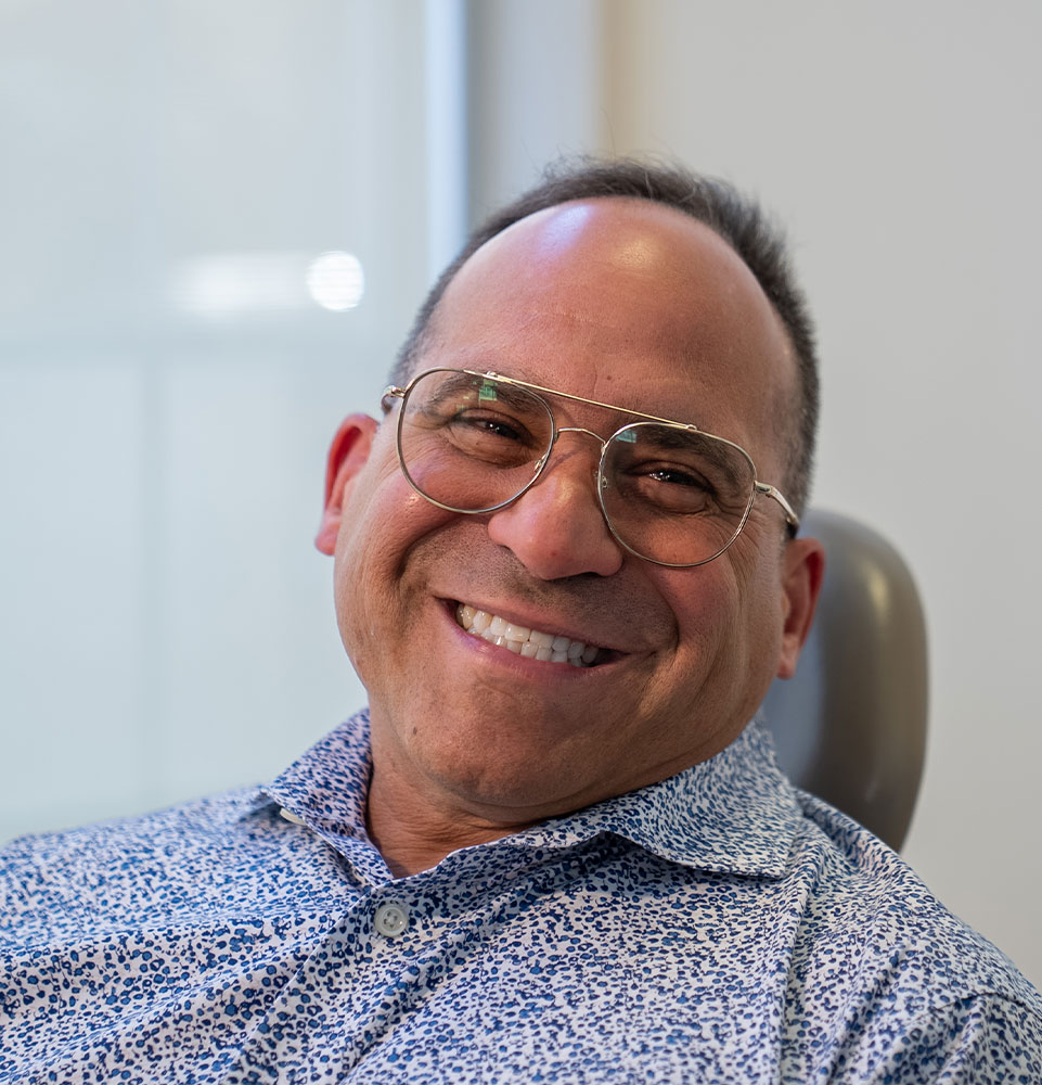 headshot of patient smiling brightly within the dental center