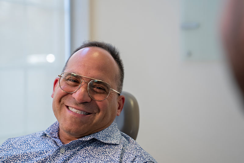 patient smiling brightly while listening to dental treatment