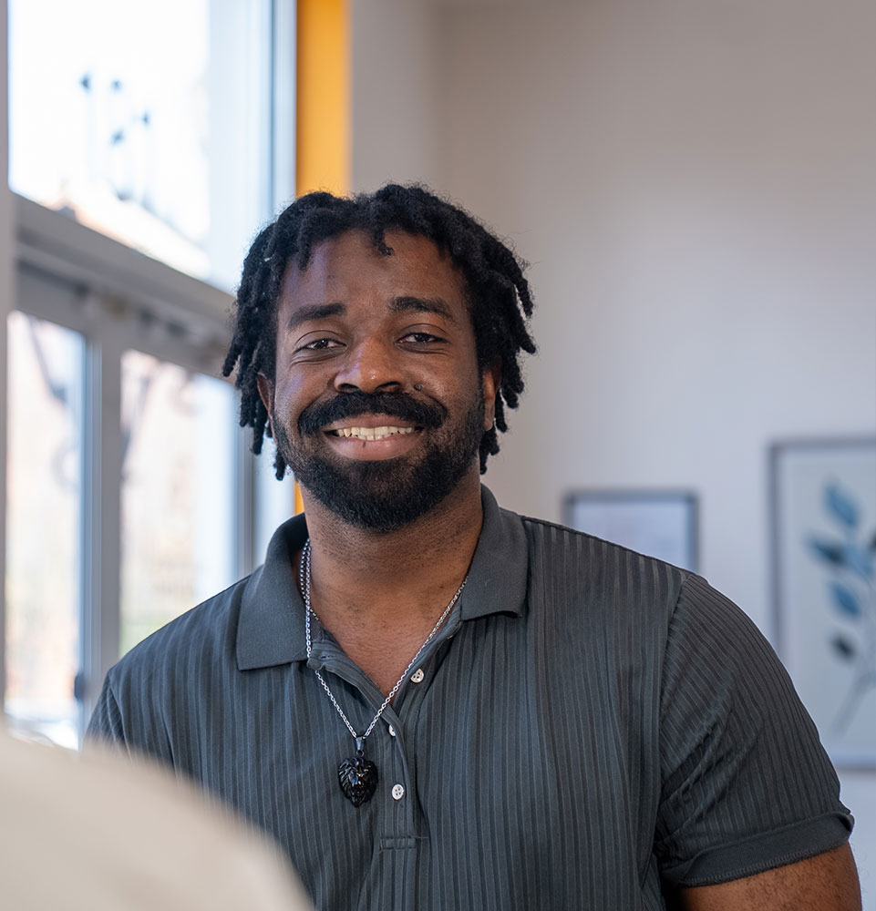 patient smiling brightly while being helped at the front desk of the dental center