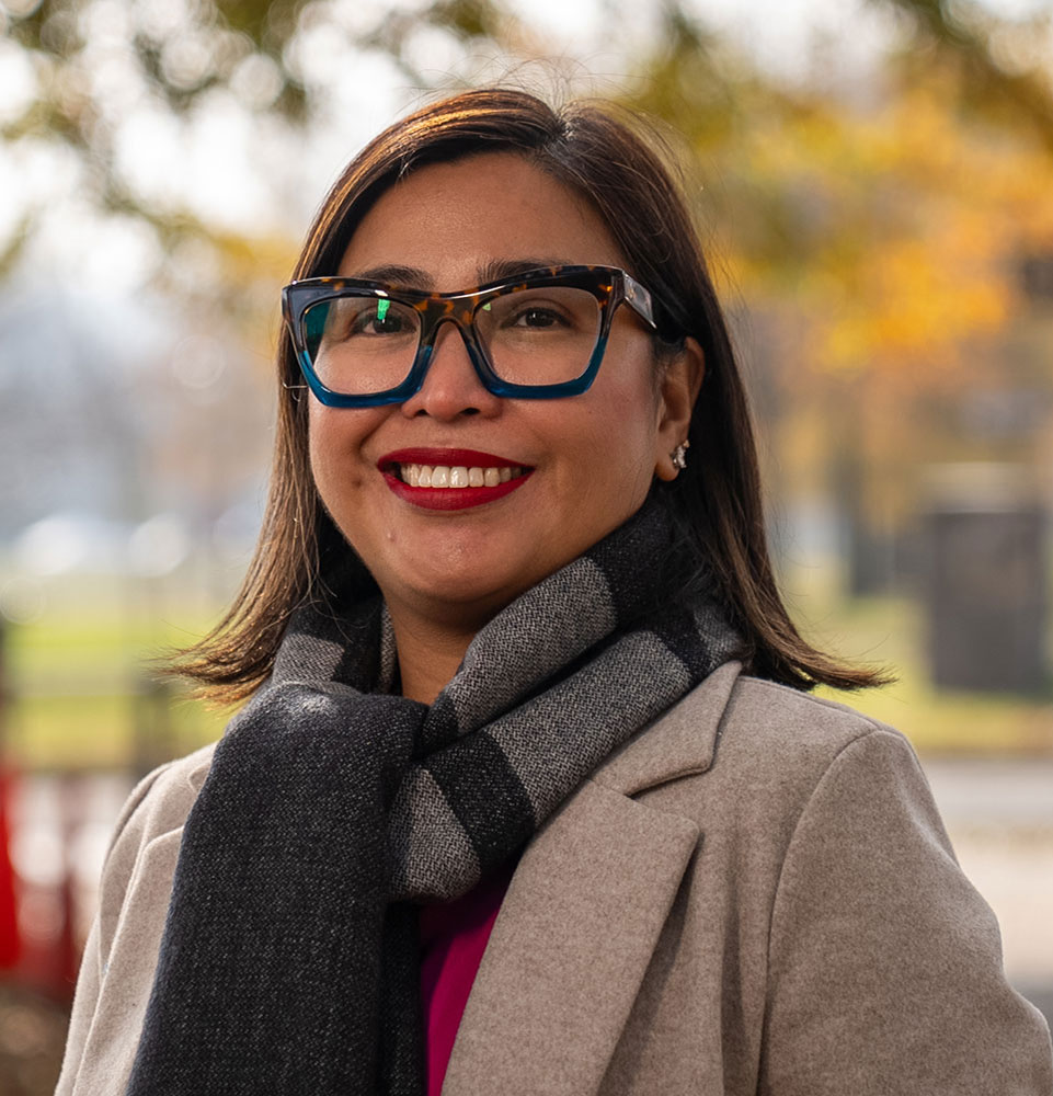 headshot of patient smiling brightly outside in a park