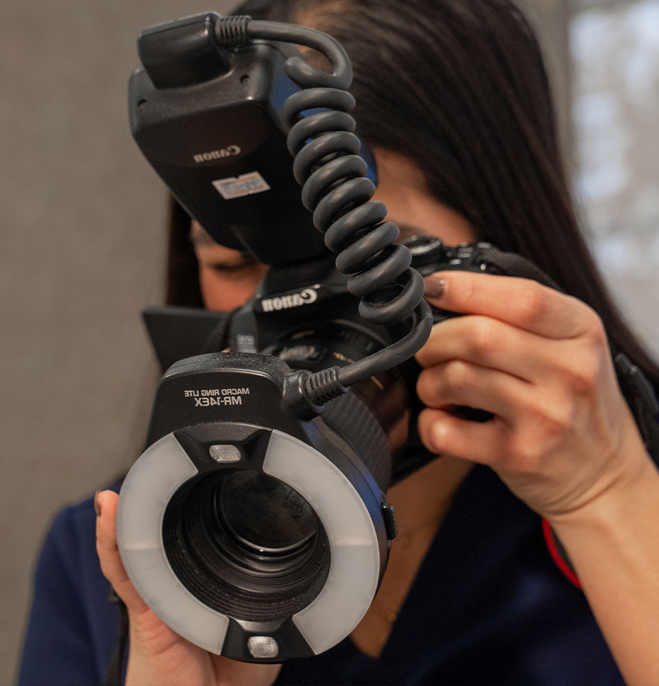 close up of staff member using camera for dental treatment